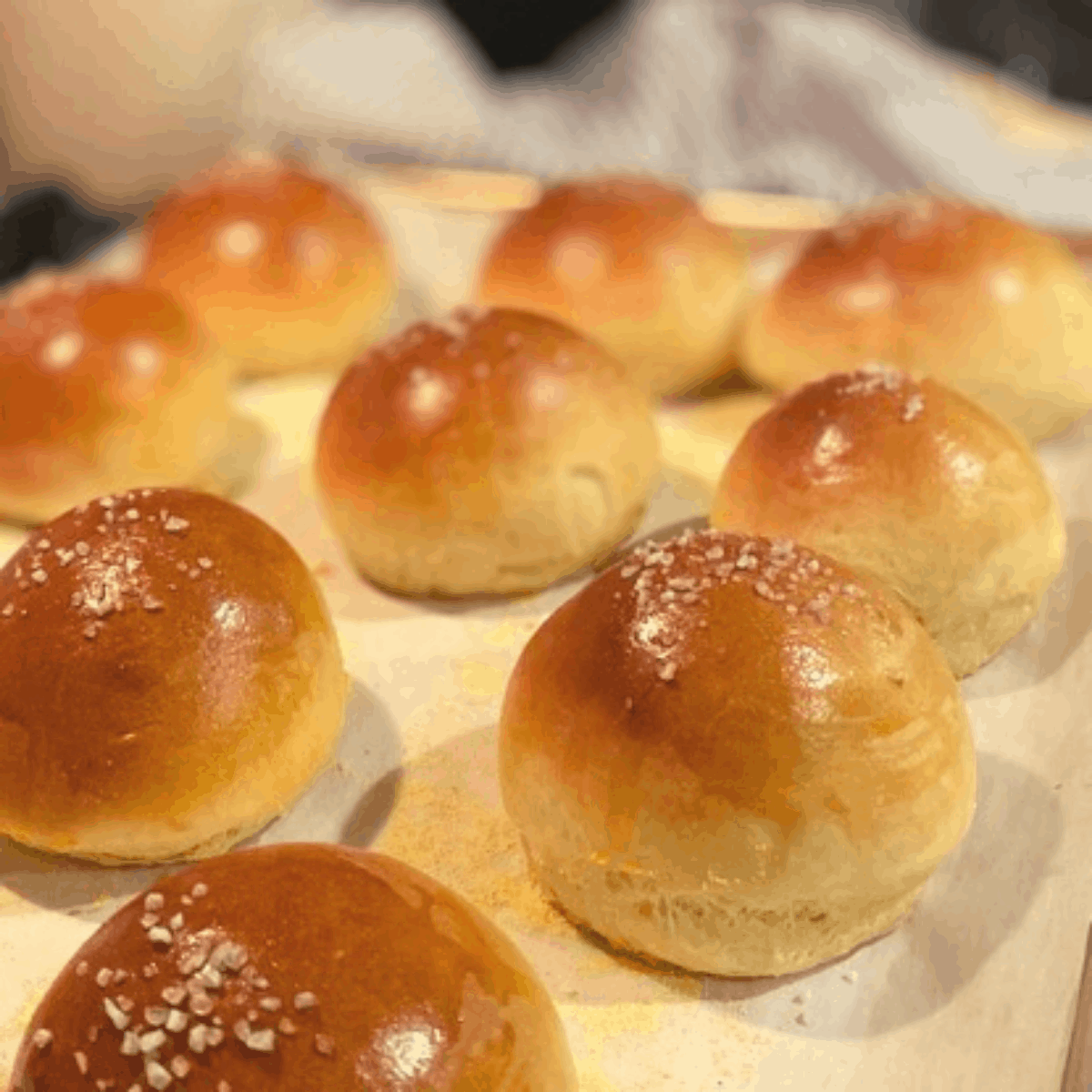 9 baked brioche buns on parchment lined baking sheet