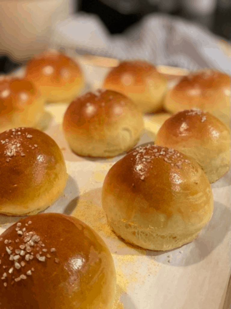 9 baked brioche buns on parchment lined baking sheet