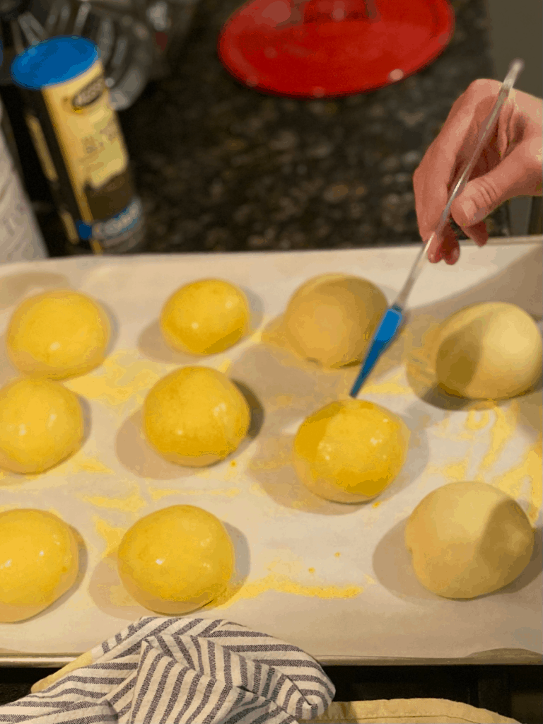 brushing egg wash on unbaked brioche buns