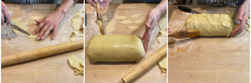 hands cutting out leaves from dough and attaching to rolled beef wellington