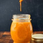 chipotle dressing dripping from spoon into glass jar