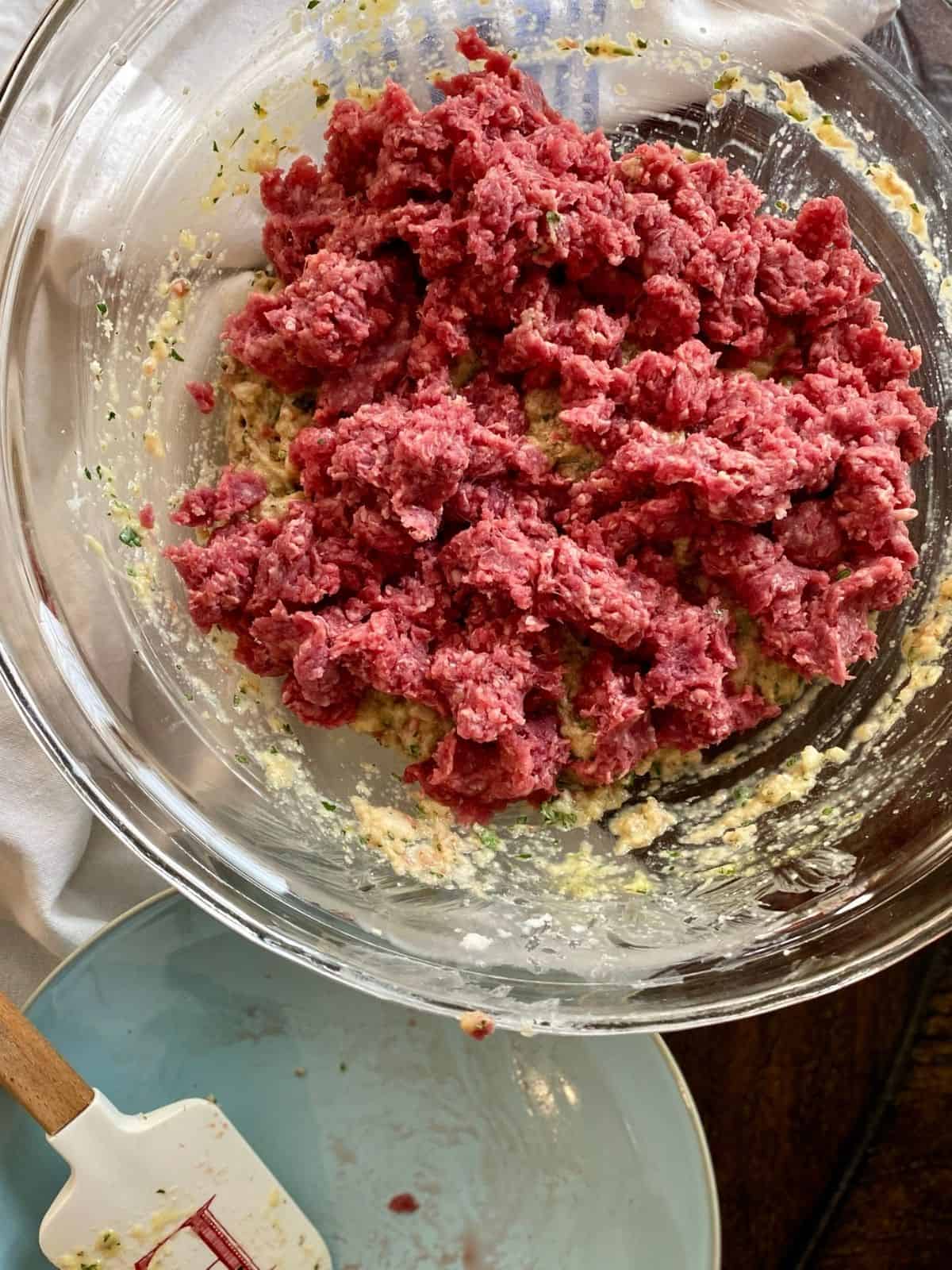 meatball mixture with remaining ground beef crumbled over top