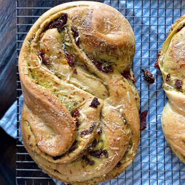 baked bread stuffed with pesto and sindried tomatoes on cooling rack