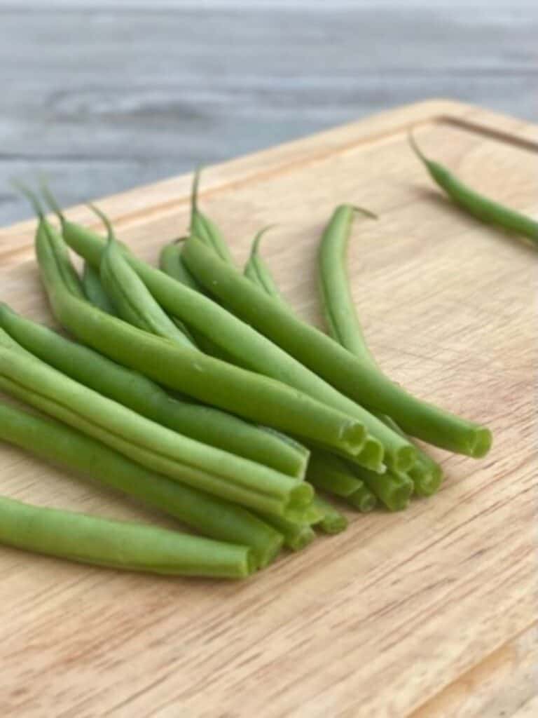 bunch of trimmed green beans on cutting board