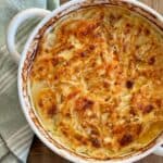 baked fennel and sweet potato gratin in round casserole next to green napkin
