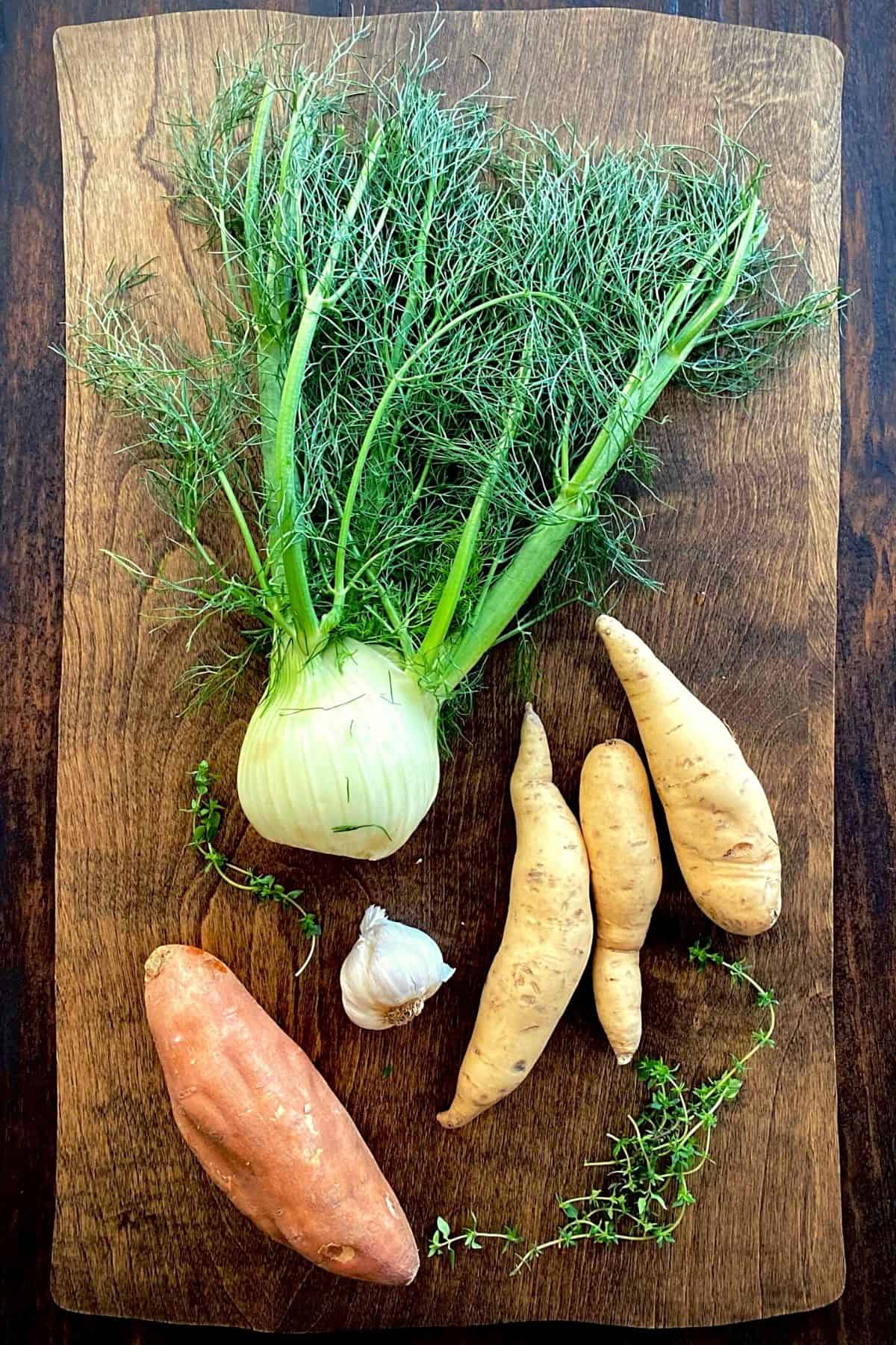 fennel, sweet potatoes, garlic and thyme on wood board