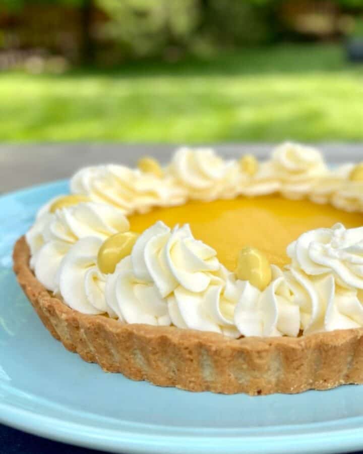 lemon tart with almond crust on blue plate