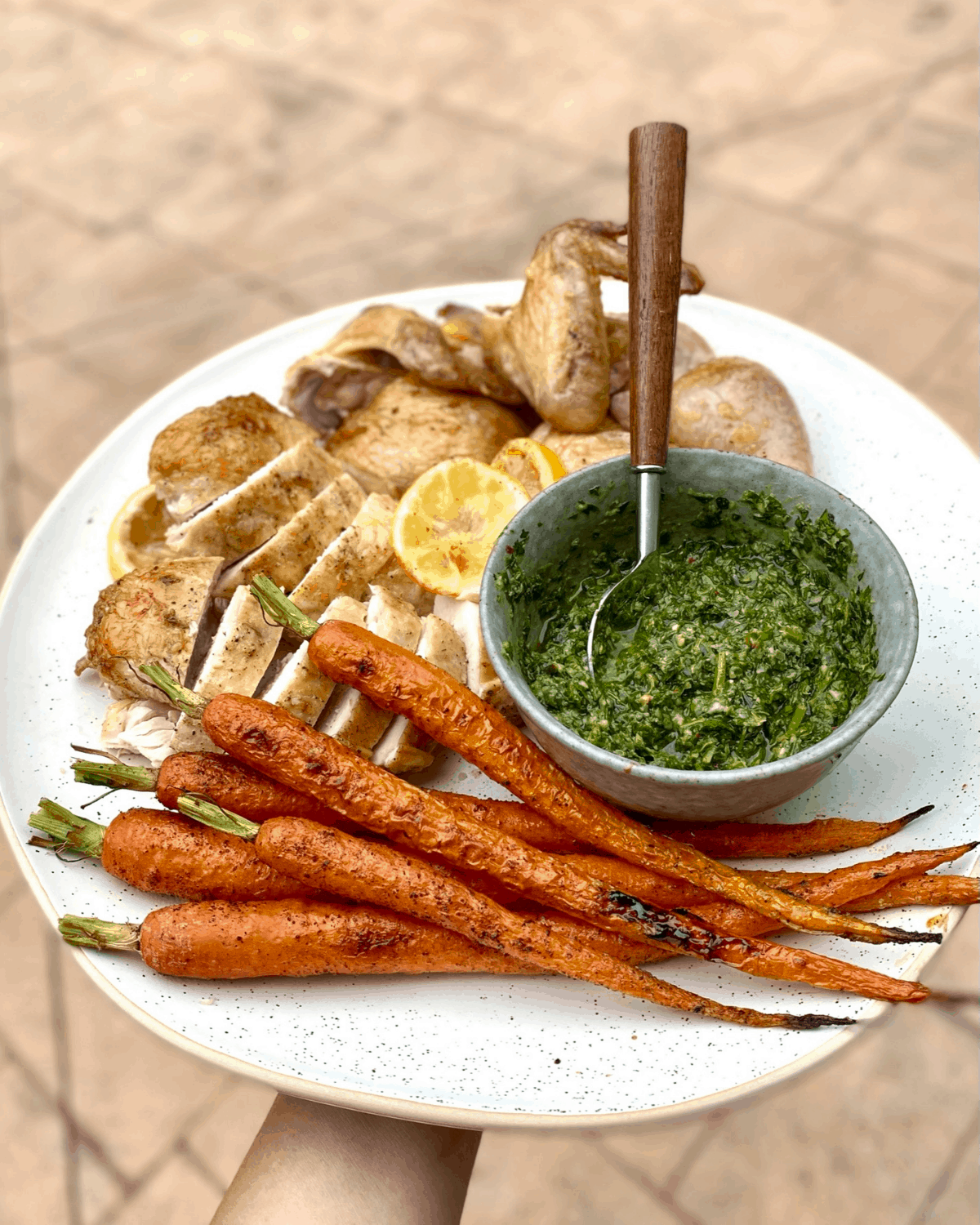 pan roasted chicken with herb salsa and roasted carrots on platter