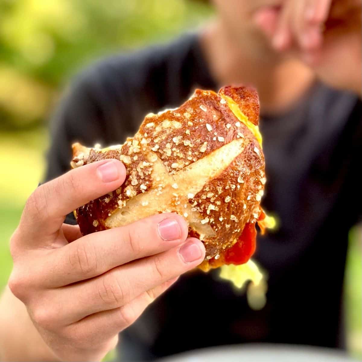 pretzel bun burger in hand