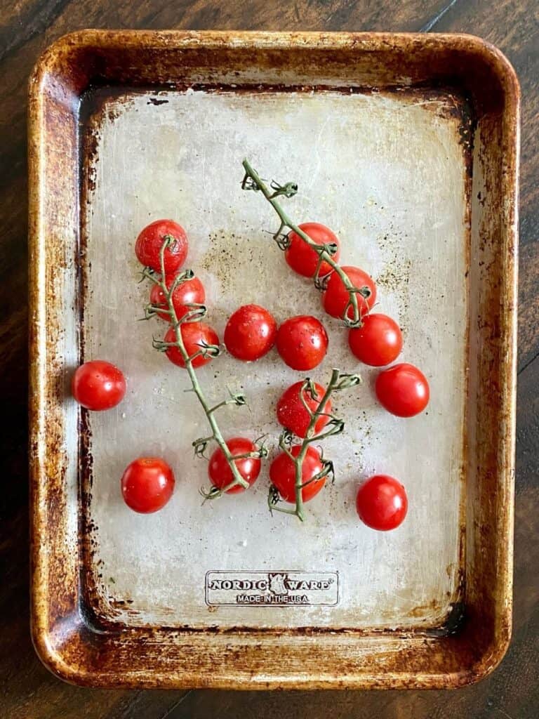 uncooked cherry tomatoes on baking sheet
