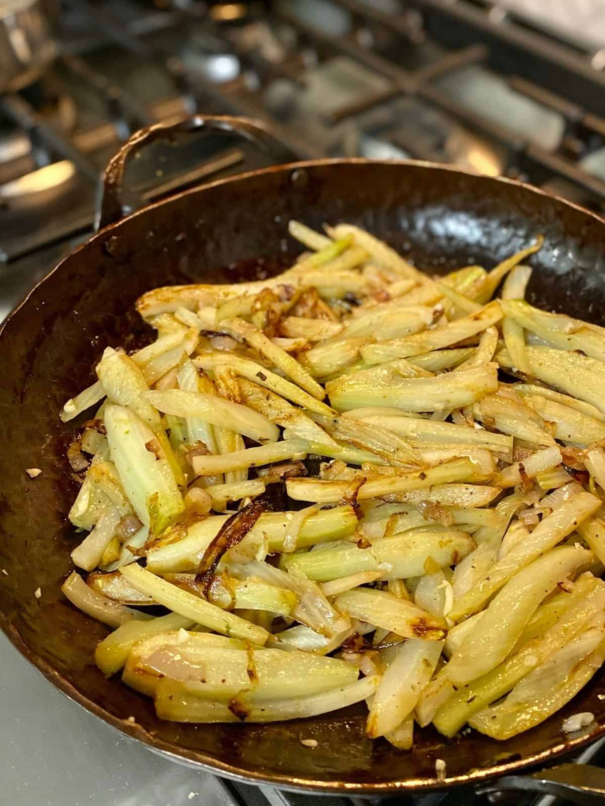 fennel and shallots cooking in pan on stove top