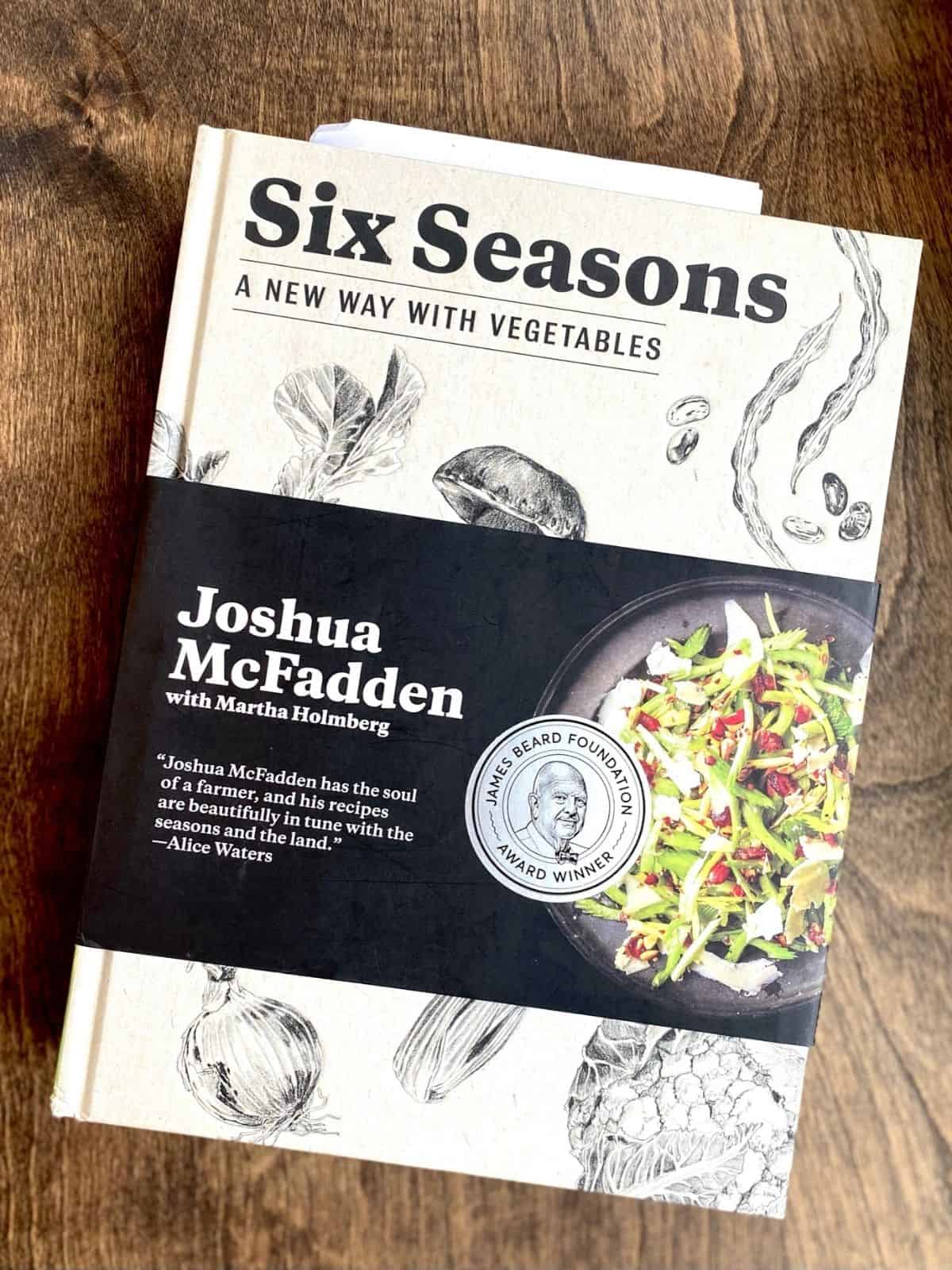 Six Seasons cookbook on wood background