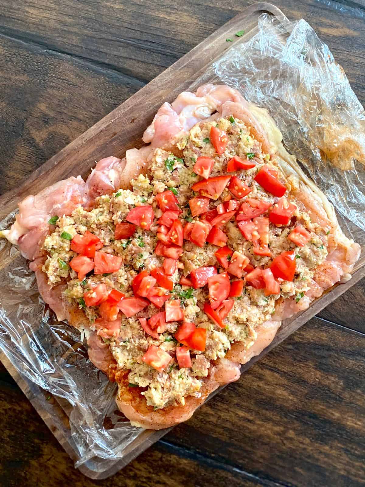 deboned chicken topped with stuffing and diced tomatoes