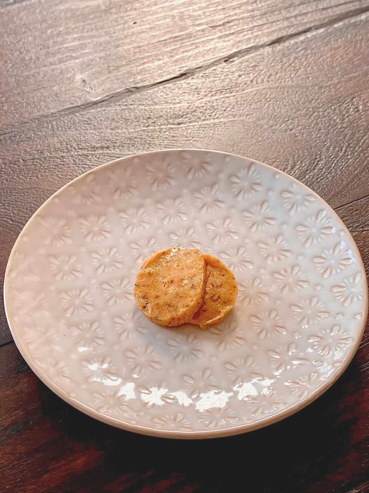 two pats of S&S citrus butter on white plate